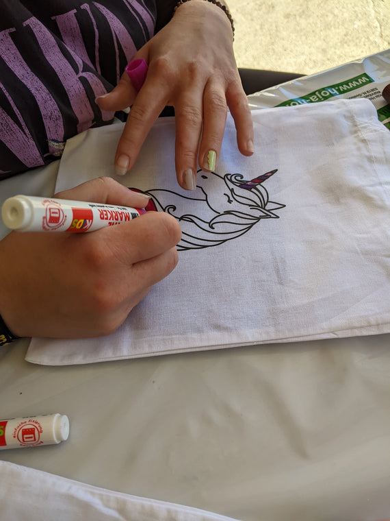 Kinder malen Stofftaschen beim Kindergeburtstag aus