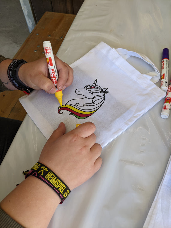 Kinder malen Stofftaschen beim Kindergeburtstag aus