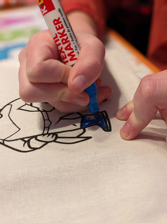 Kinder malen Stofftaschen beim Kindergeburtstag aus