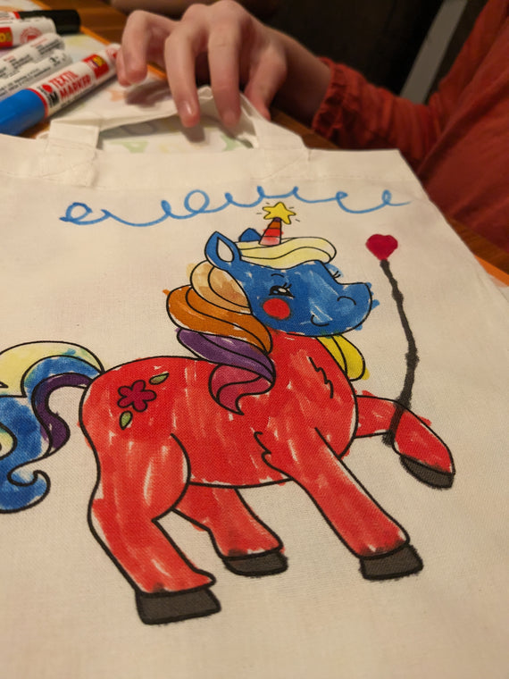 Kinder malen Stofftaschen beim Kindergeburtstag aus