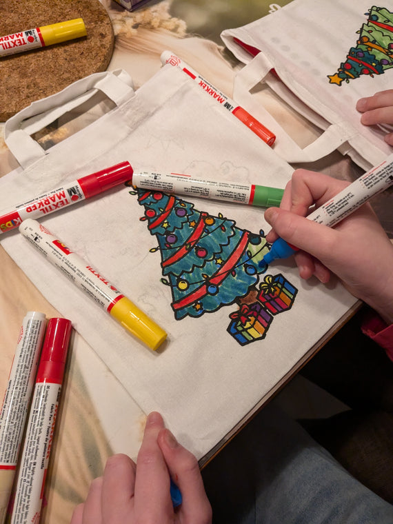 Kinder malen Stofftaschen beim Kindergeburtstag aus