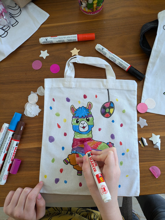 Kinder malen Stofftaschen beim Kindergeburtstag aus
